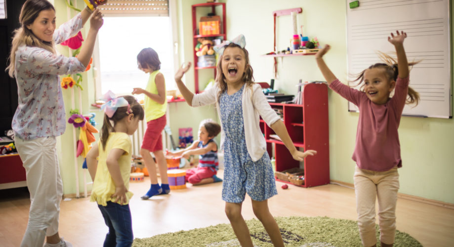 little girl dancing in classroom with friends
